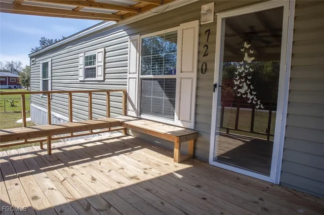 a view of a balcony with wooden floor and a floor to ceiling window