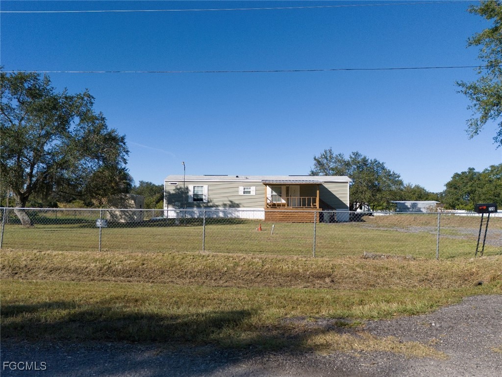 720 North Estribo Street Clewiston, FL 33440 - Photo 25 of 39 a view of a lake with a house in the background