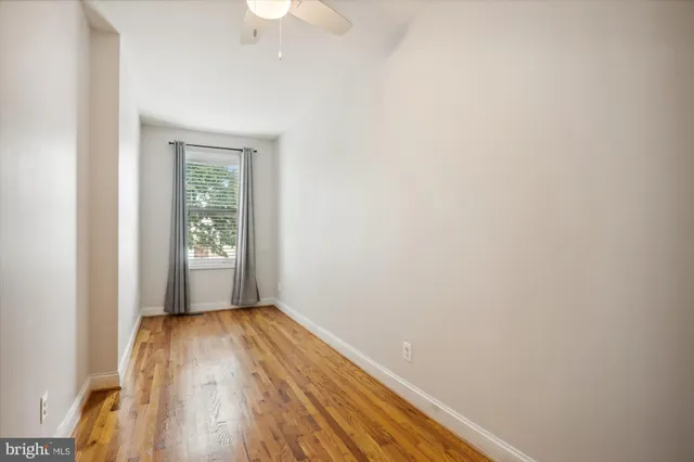 a view of a room with wooden floor and a window