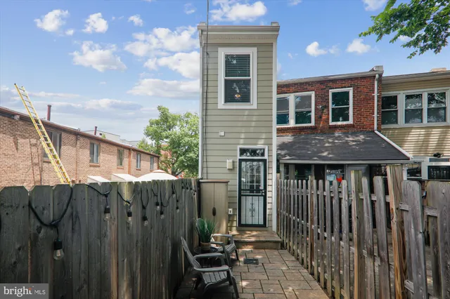 a view of a house with a small yard and wooden fence