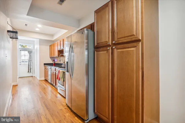 a view of a kitchen with wooden floor and electronic appliances