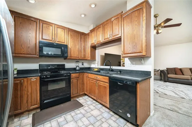 a kitchen with stainless steel appliances granite countertop a stove a sink and a microwave
