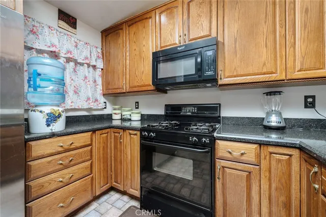 a kitchen with granite countertop cabinets stainless steel appliances and wooden cabinets
