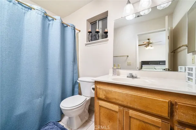 a bathroom with a sink a toilet a mirror and shower curtain