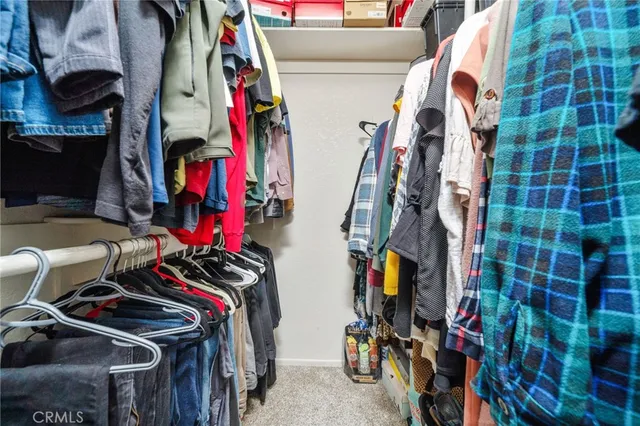a view of walk in closet with clothes