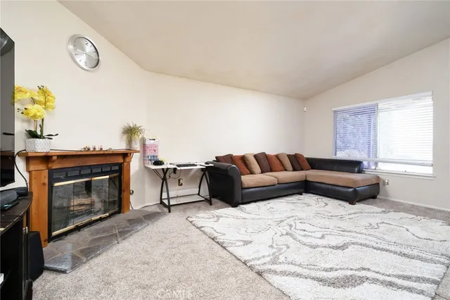 a living room with furniture a fireplace and a window