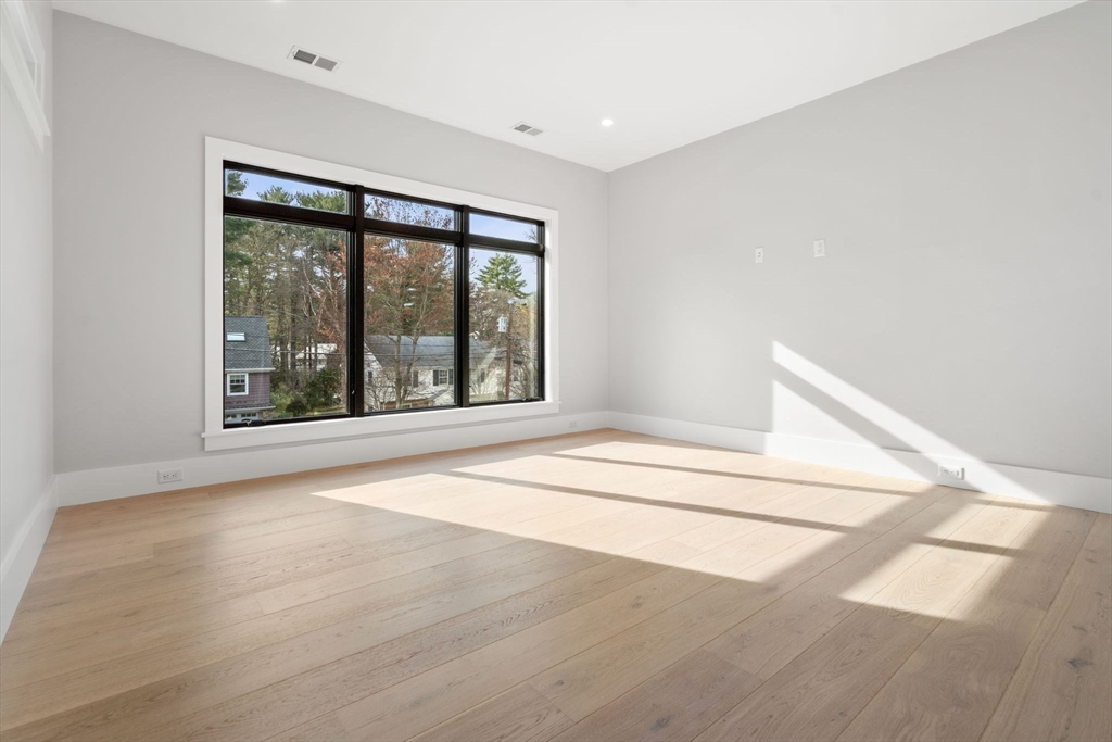 56 Upland Road Newton, MA 02468 - Photo 26 of 41 a view of an empty room with wooden floor and a window