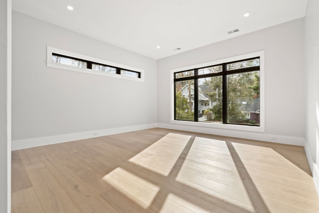 56 Upland Road Newton, MA 02468 - Photo 28 of 41 a view of an empty room with wooden floor and a window