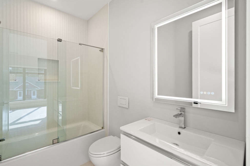 56 Upland Road Newton, MA 02468 - Photo 30 of 41 a bathroom with a bathtub shower sink vanity and toilet