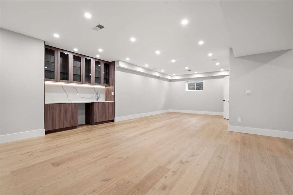 56 Upland Road Newton, MA 02468 - Photo 36 of 41 an empty room with wooden floor and fireplace