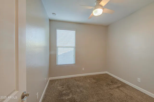 an empty room with a fan and a window
