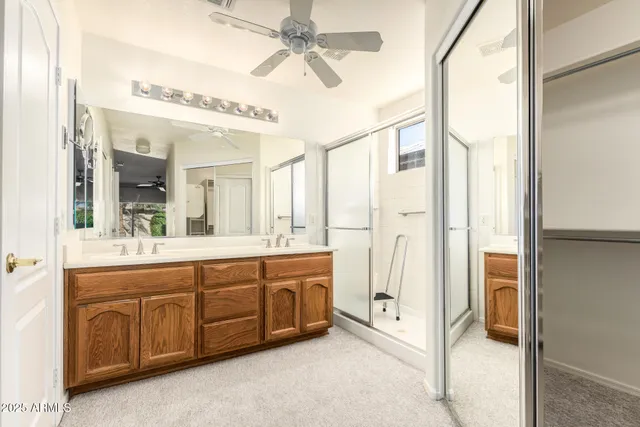 a spacious bathroom with a shower a sink and a mirror