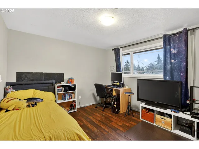 a bedroom with furniture and a flat screen tv