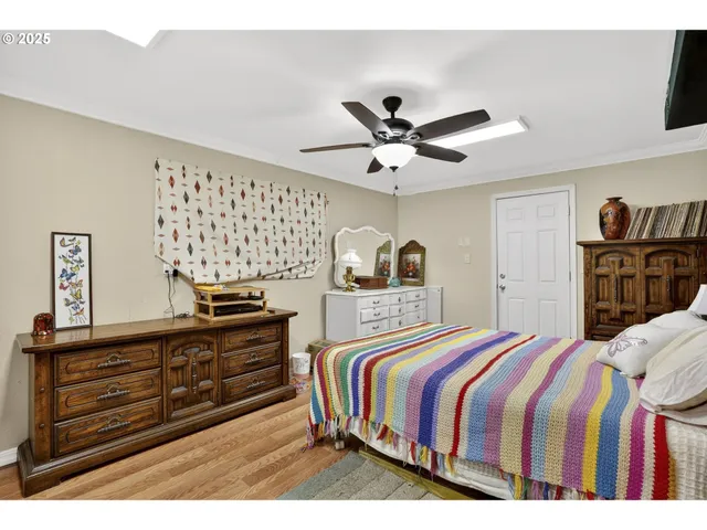 a bedroom with a bed a dresser and potted plants