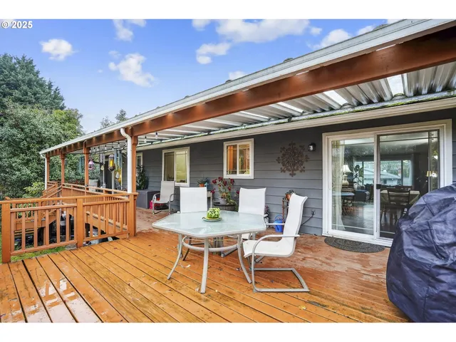 a view of a patio with table and chairs with wooden floor and fence