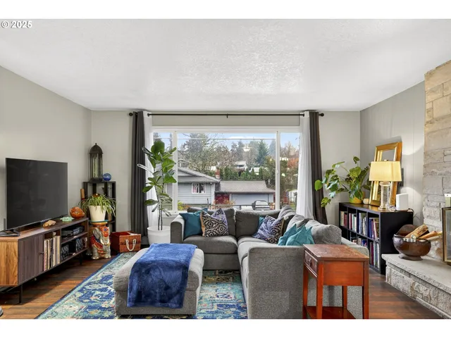 a living room with furniture a flat screen tv and a floor to ceiling window
