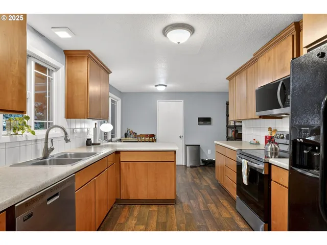 a kitchen with stainless steel appliances a sink stove and refrigerator