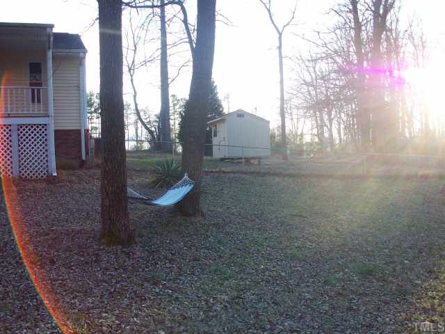 7112 Blalock Road Bahama, NC 27503 - Photo 3 of 12 a backyard of a house with barbeque oven and trees