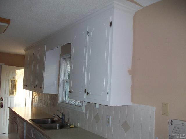 7112 Blalock Road Bahama, NC 27503 - Photo 10 of 12 a kitchen with granite countertop white cabinets and stainless steel appliances