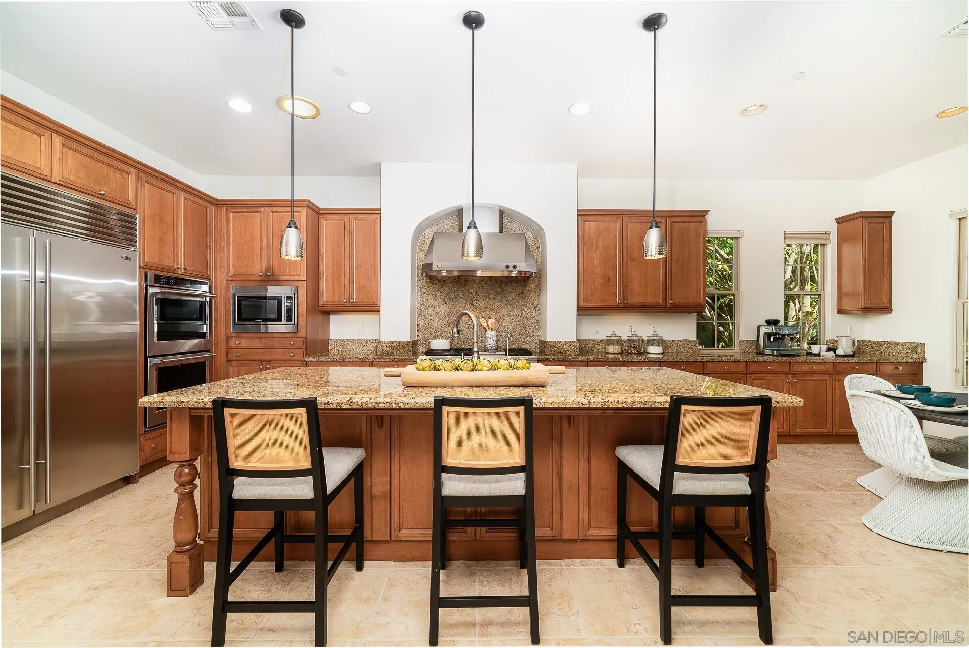 14757 Whispering Ridge Road San Diego, CA 92131 - Photo 24 of 48 a kitchen with stainless steel appliances granite countertop a stove a refrigerator a oven a kitchen island a dining table and chairs