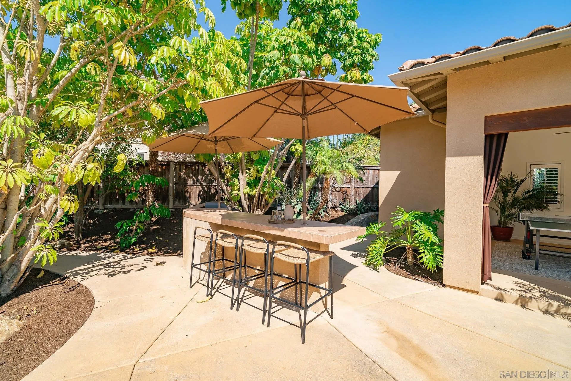 14757 Whispering Ridge Road San Diego, CA 92131 - Photo 27 of 48 a view of patio with chairs and table under an umbrella