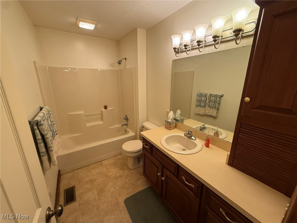 2597 Pyle Road Dover, OH 44622 - Photo 33 of 50 Bathroom with vanity, shower / tub combination, a textured ceiling, and tile patterned flooring
