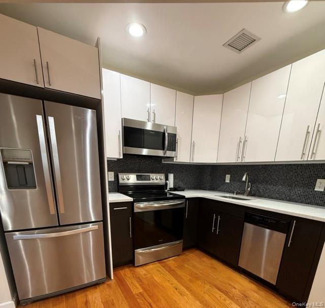 31-10 28th Road, Unit 3D Queens, NY 11102 - Photo 6 of 11 a kitchen with a sink a refrigerator and cabinets