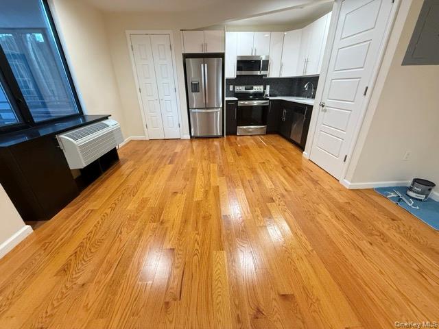 31-10 28th Road, Unit 3D Queens, NY 11102 - Photo 9 of 11 a kitchen with a sink wooden floor and stainless steel appliances