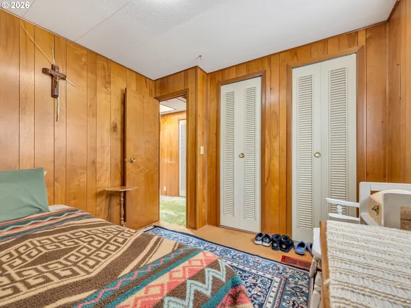 a bedroom with a bed and a dresser with mirror