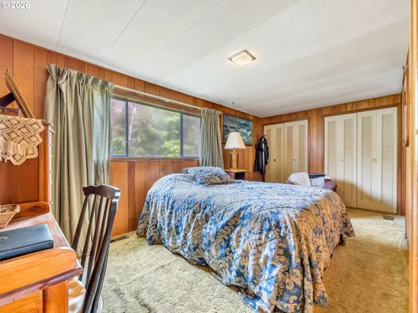 a bed sitting in a bedroom next to a window