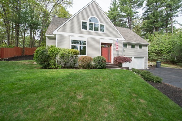 a front view of a house with a yard and trees