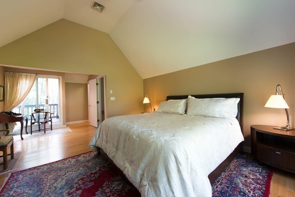 8 Frost Street Natick, MA 01760 - Photo 14 of 28 a spacious bedroom with a bed a table and painting on the wall