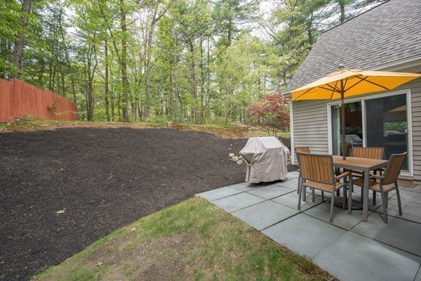 8 Frost Street Natick, MA 01760 - Photo 27 of 28 a backyard of a house with table and chairs under an umbrella