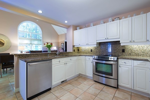 8 Frost Street Natick, MA 01760 - Photo 7 of 28 a kitchen with granite countertop white cabinets stainless steel appliances a sink and a window