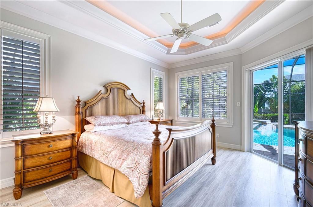 3002 Crayton Road Naples, FL 34103 - Photo 17 of 27 a bedroom with a bed and large windows