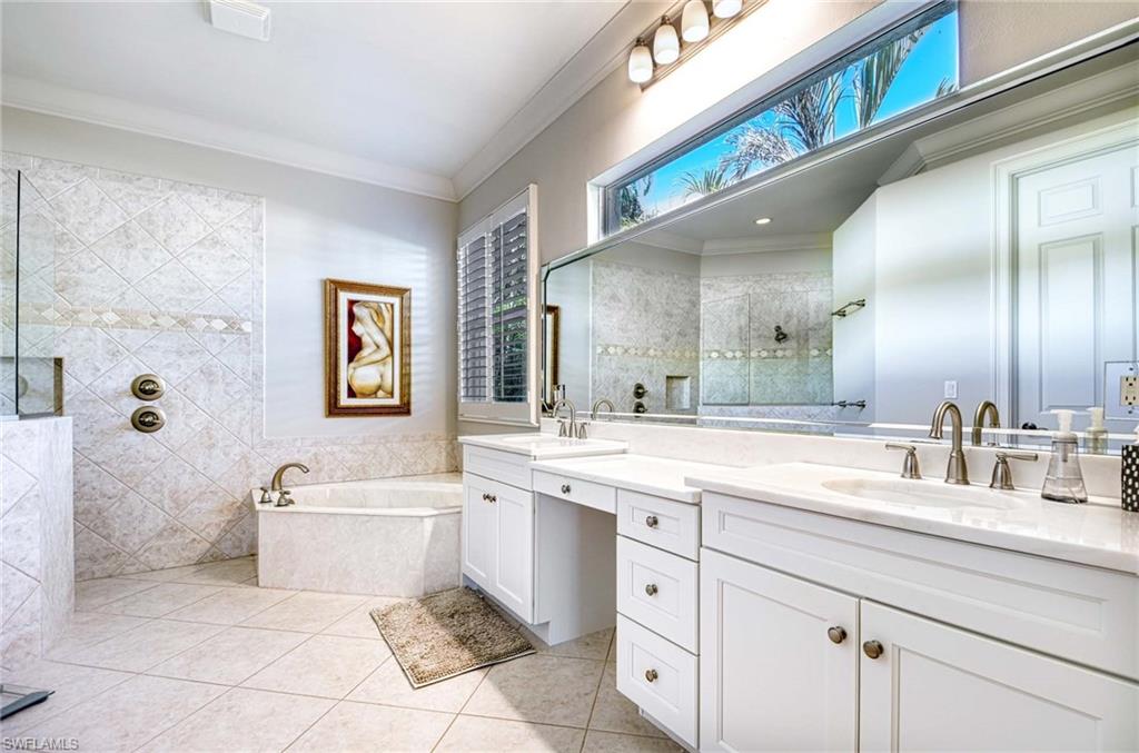 3002 Crayton Road Naples, FL 34103 - Photo 18 of 27 a spacious bathroom with a sink a mirror and a bathtub