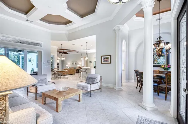 a living room with furniture a table and chairs with floor to ceiling window