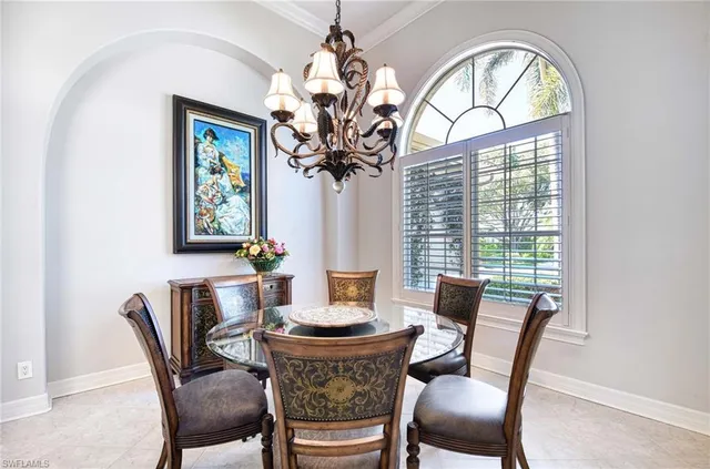 a dining room with furniture a large window and a chandelier