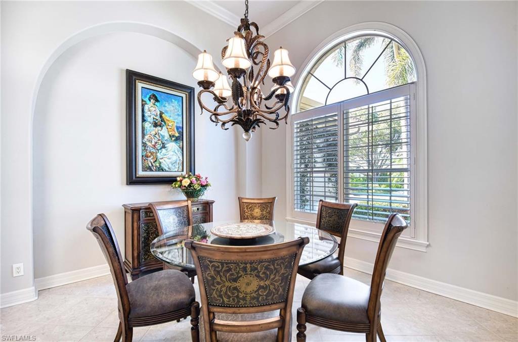 3002 Crayton Road Naples, FL 34103 - Photo 7 of 27 a dining room with furniture a large window and a chandelier