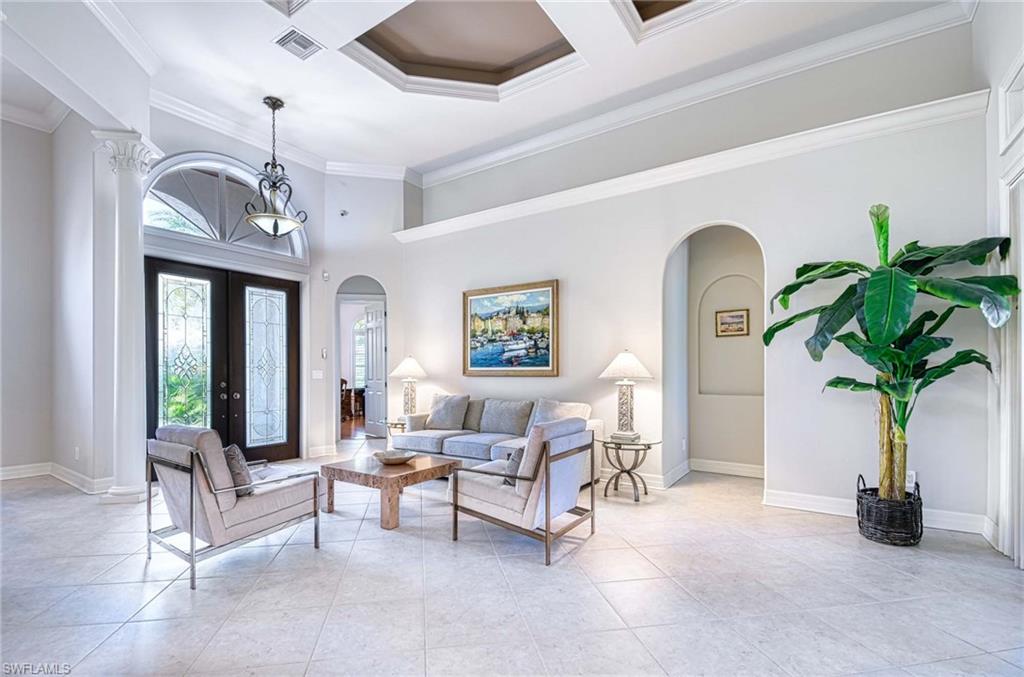 3002 Crayton Road Naples, FL 34103 - Photo 8 of 27 a living room with furniture flowers and a chandelier