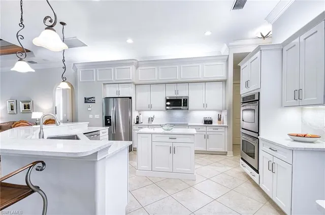 a kitchen with kitchen island white cabinets and refrigerator