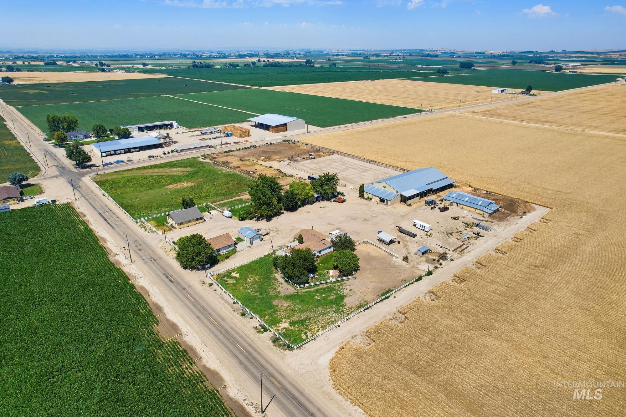 24900 Market Road Parma, ID 83660 - Photo 30 of 50 Expansive agricultural property featuring multiple outbuildings with metal roofs, residential structures, and surrounding cultivated fields