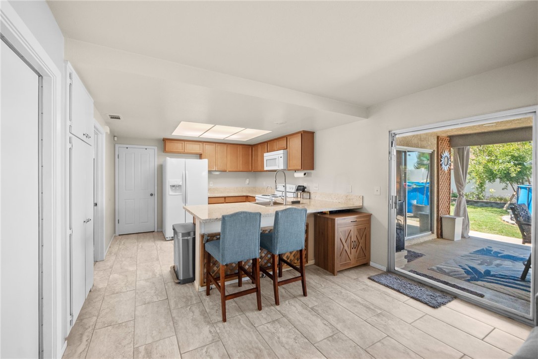 27879 Foxfire Street Menifee, CA 92586 - Photo 16 of 36 a kitchen with stainless steel appliances granite countertop a sink and a refrigerator