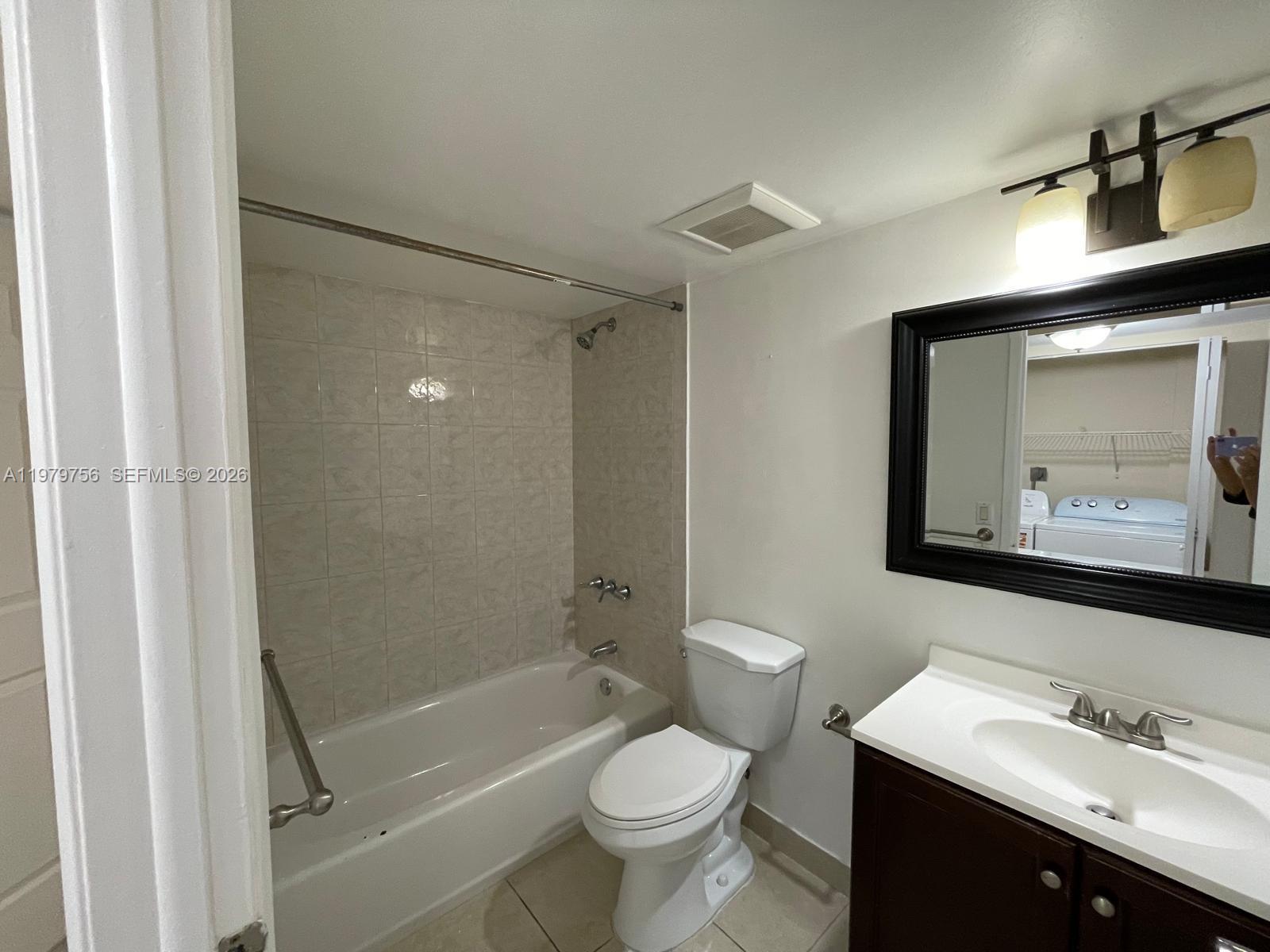 8002 Southwest 149th Avenue, Unit B409 Miami, FL 33193 - Photo 14 of 23 a bathroom with a bathtub shower sink mirror and toilet