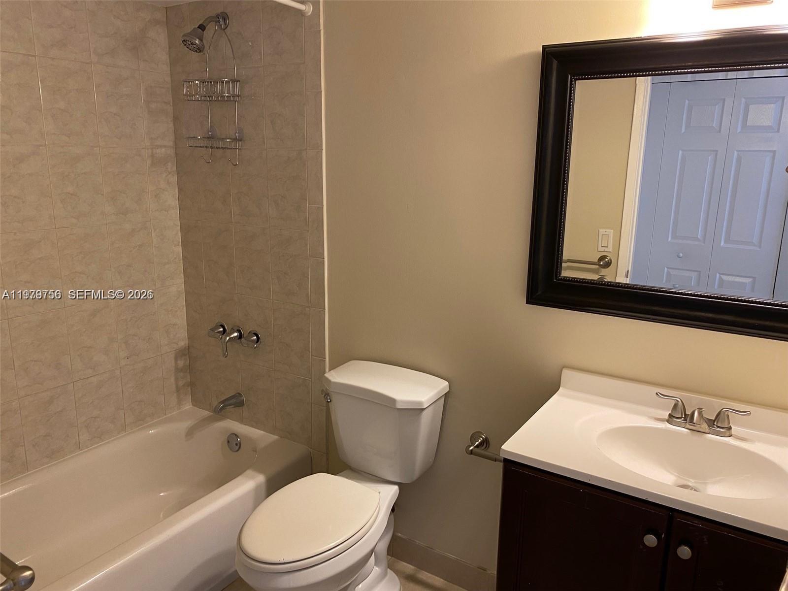 8002 Southwest 149th Avenue, Unit B409 Miami, FL 33193 - Photo 14 of 15 a bathroom with a sink a toilet and shower