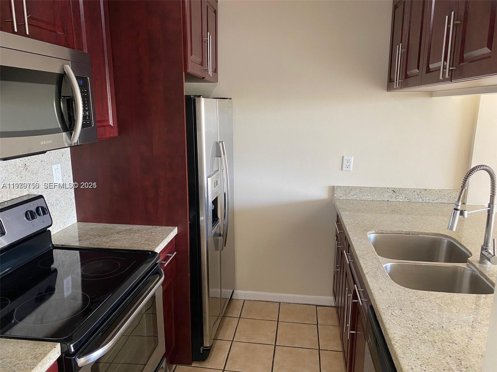 8002 Southwest 149th Avenue, Unit B409 Miami, FL 33193 - Photo 2 of 15 a kitchen with a sink stove and refrigerator