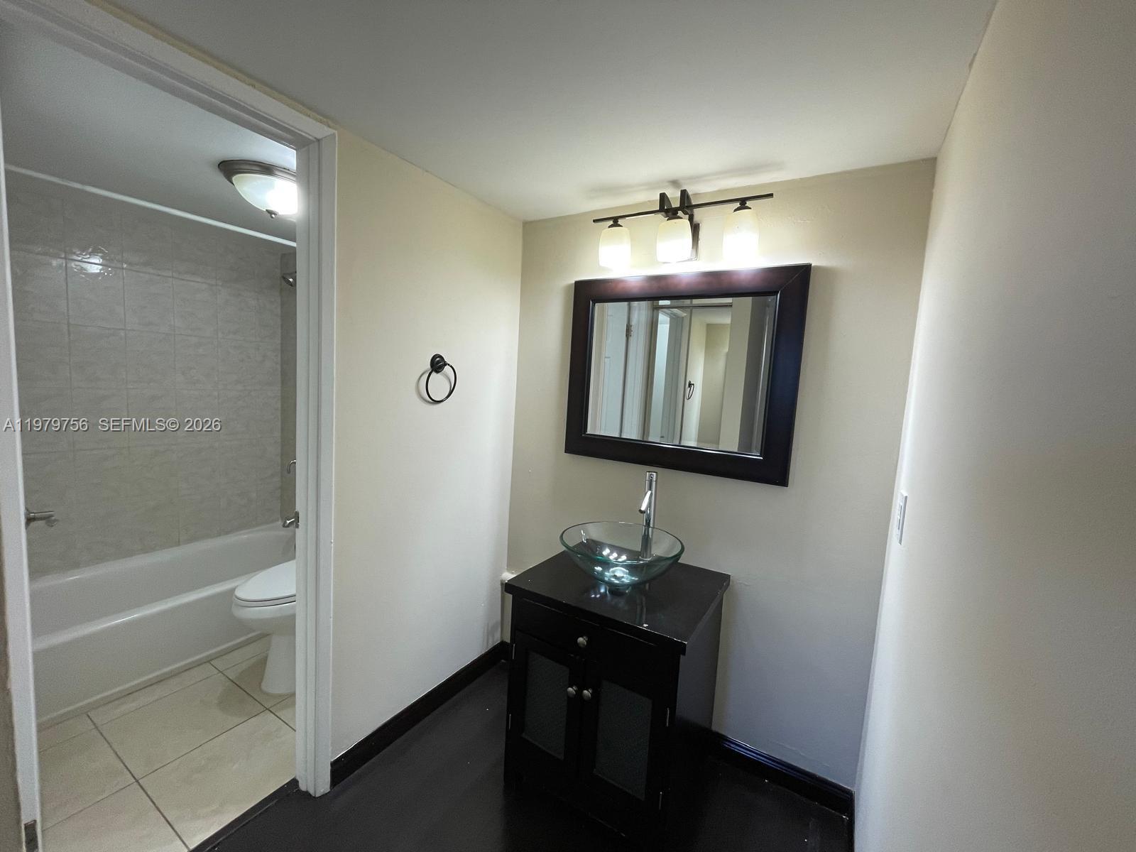 8002 Southwest 149th Avenue, Unit B409 Miami, FL 33193 - Photo 21 of 23 a bathroom with a sink a light fixture and a mirror