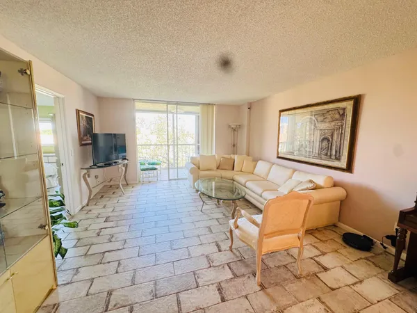 a living room with furniture a flat screen tv and a window