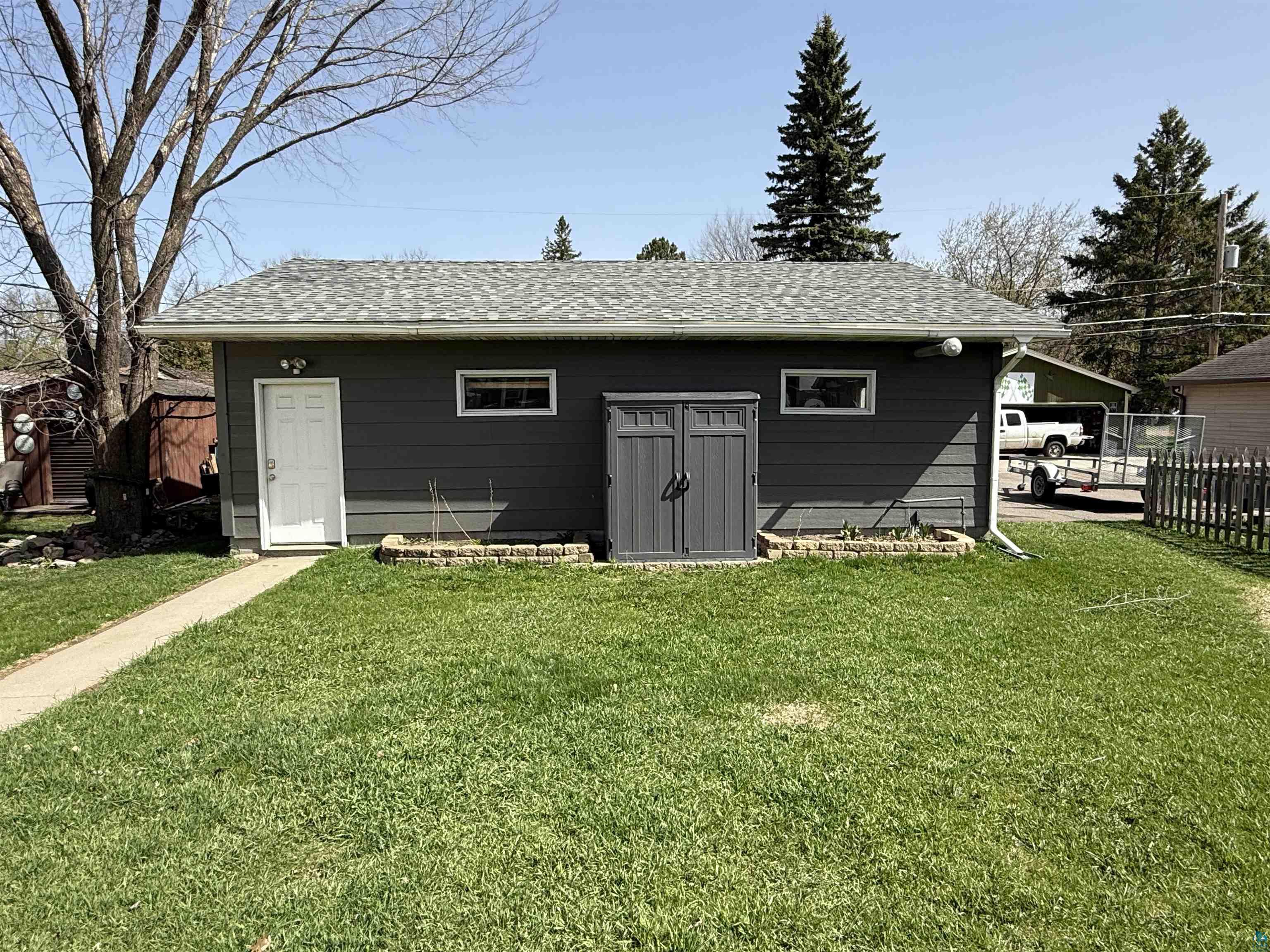 1321 South 13th Street Virginia, MN 55792 - Photo 29 of 33 Detached structure featuring dark gray horizontal siding, an asphalt shingle roof, and a white entry door