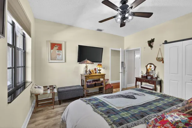 a bedroom with a bed and a flat tv screen on dresser